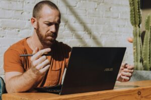 un homme assis à une table utilisant un ordinateur portable