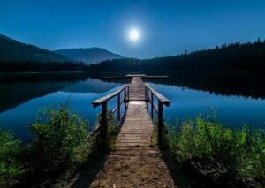 Découvrez la tranquillité sur un quai au clair de lune à Whistler, en Colombie-Britannique, sous un ciel étoilé.