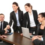 équipe professionnelle échangeant, serrant la main autour d'un ordinateur