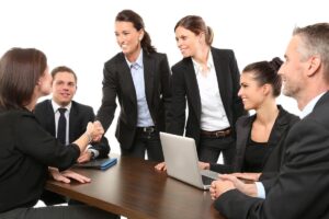 équipe professionnelle échangeant, serrant la main autour d'un ordinateur