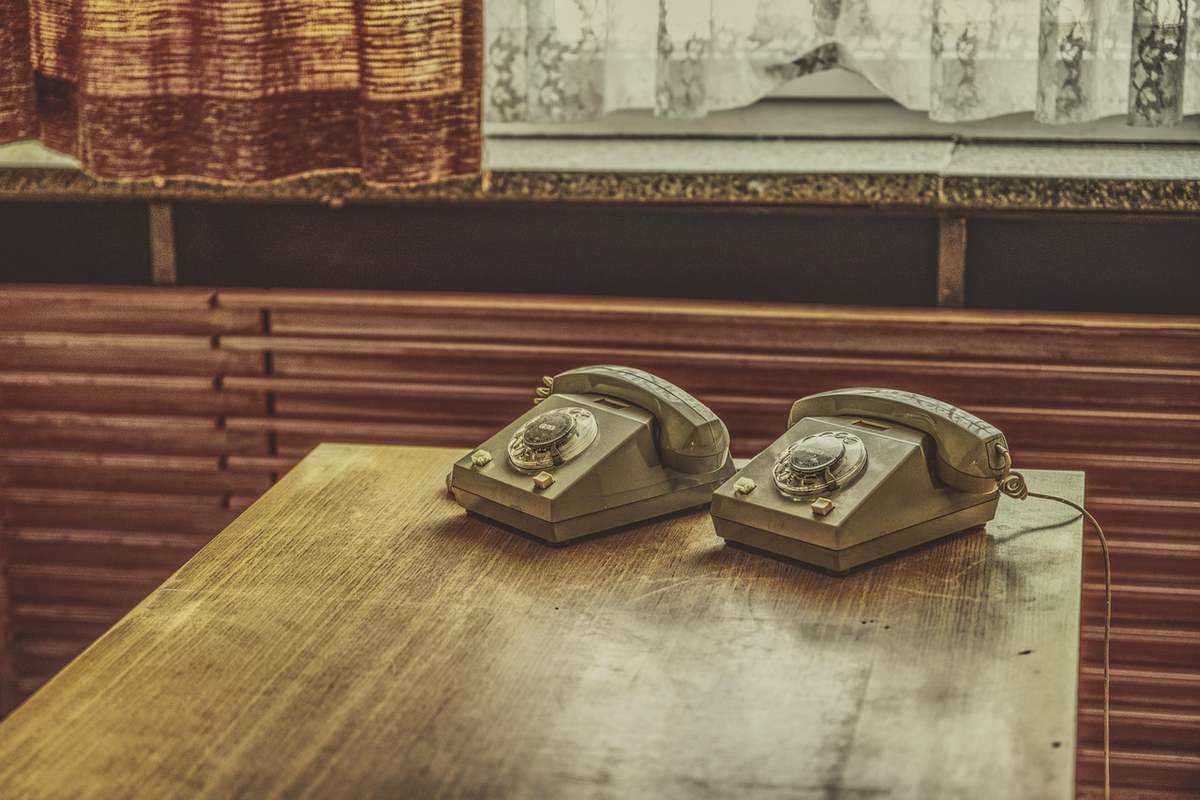 Deux téléphones sur une table en bois, devant une fenêtre