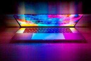 Un ordinateur portable ouvert sur une surface, écran coloré et clavier visibles