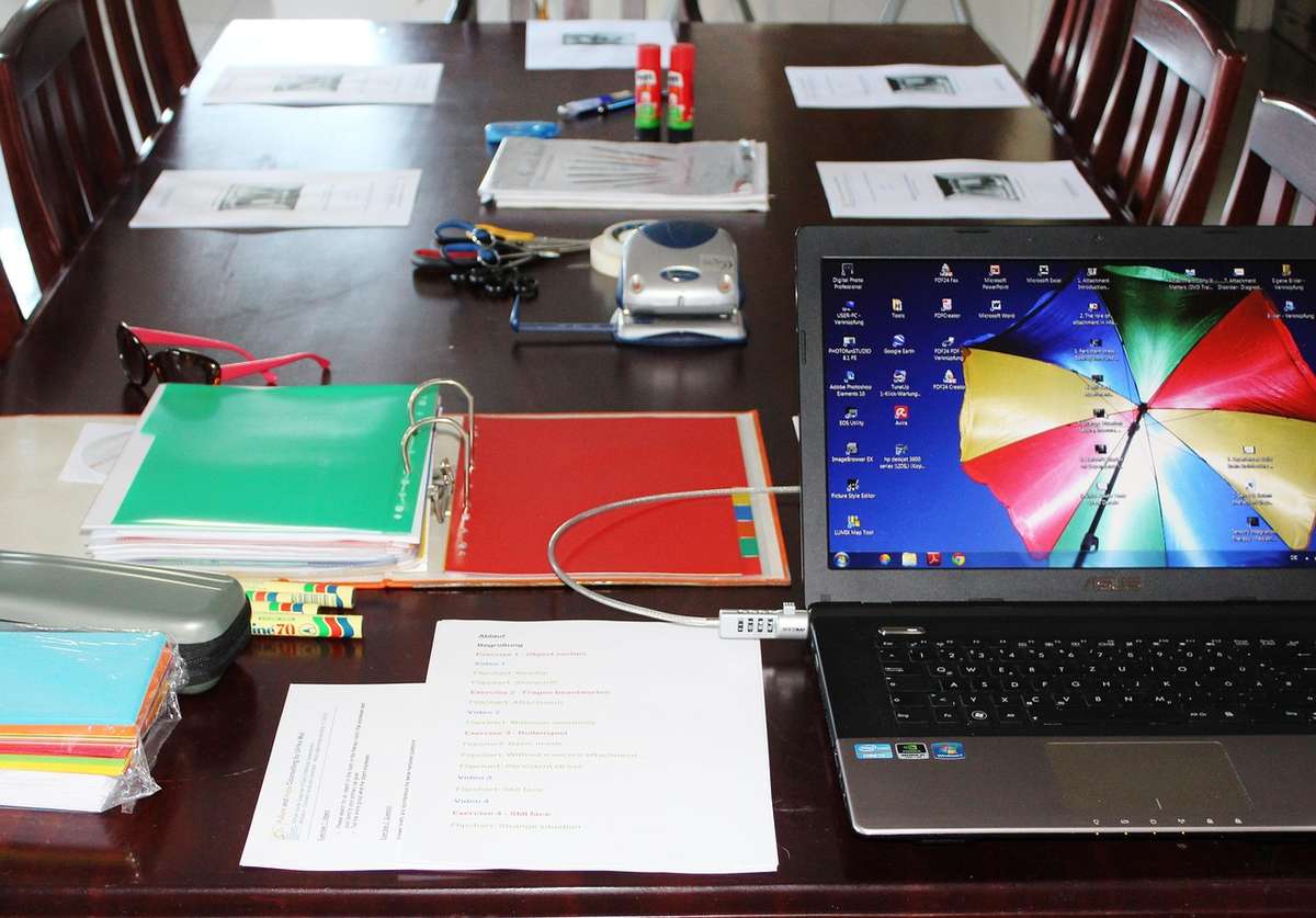 Ordinateur portable ouvert sur un bureau avec classeurs et documents